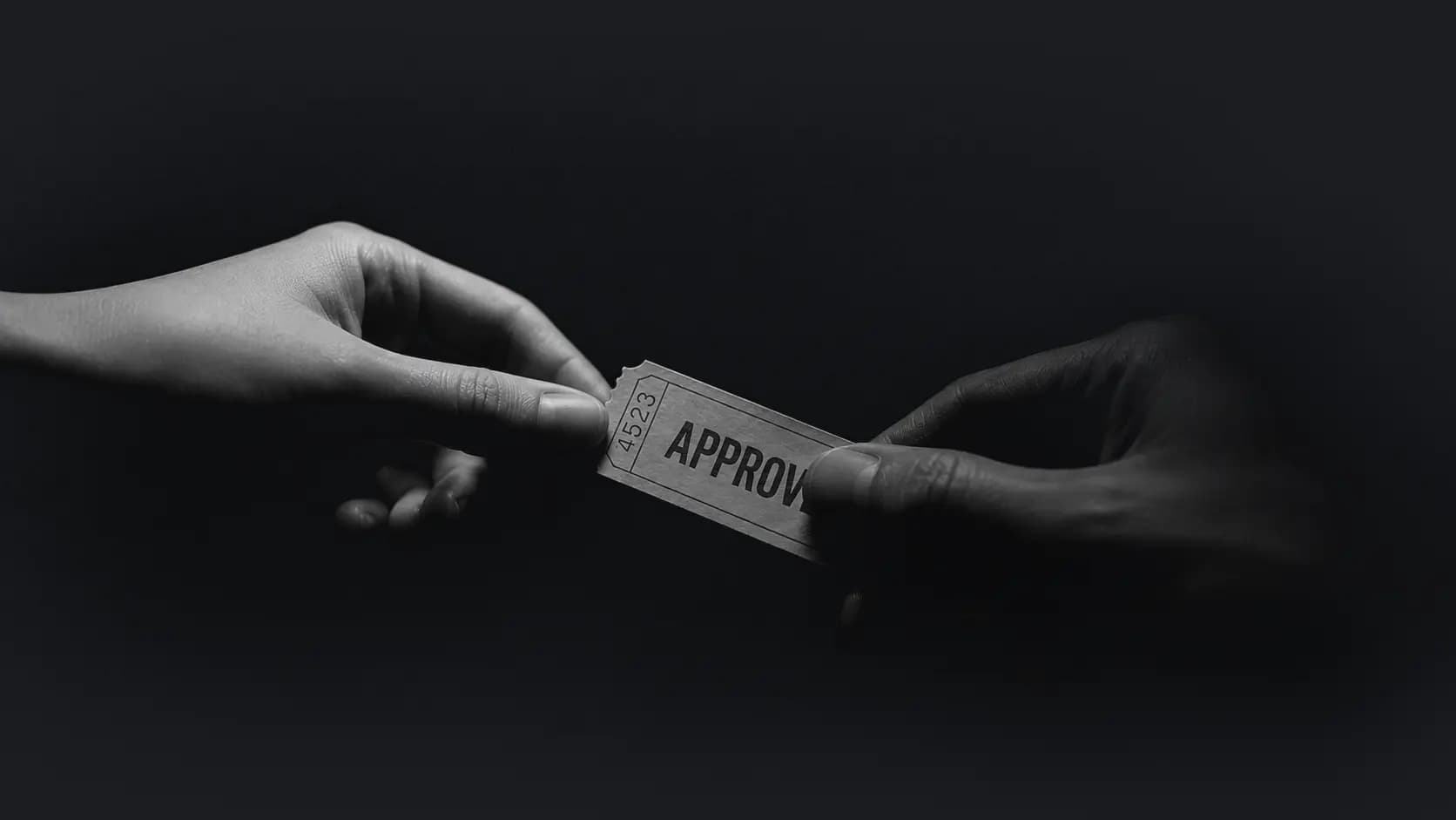 A ticket marked approved, passed from one hand to another.